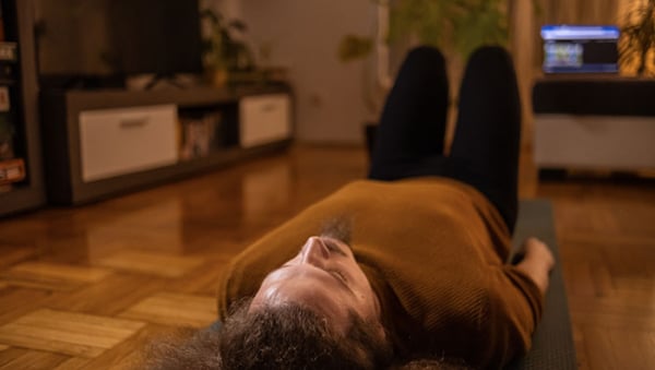 One young man doing the Kegel exercise on the mat